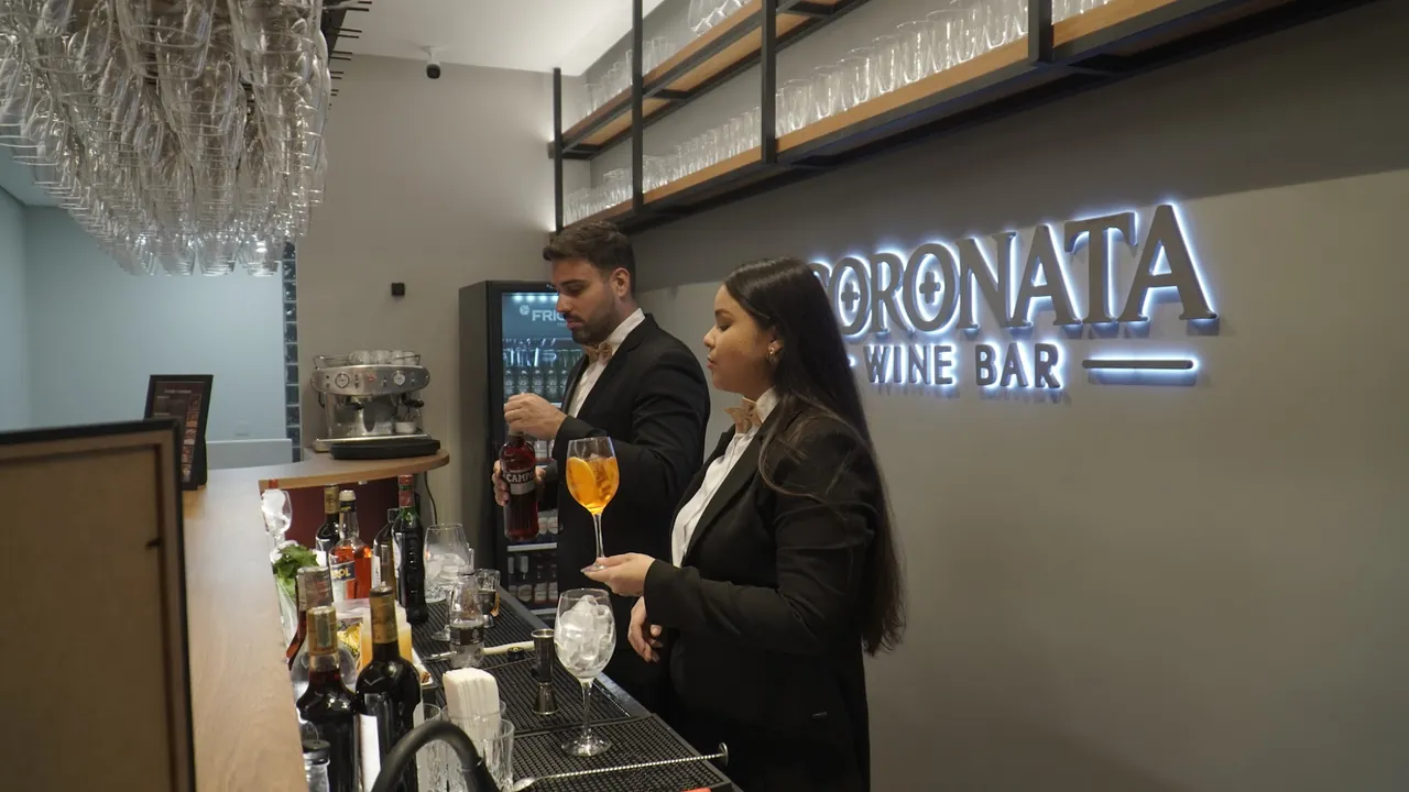 Bartenders servindo drinks no balcão do Coronata Wine Bar durante a inauguração do Conecta