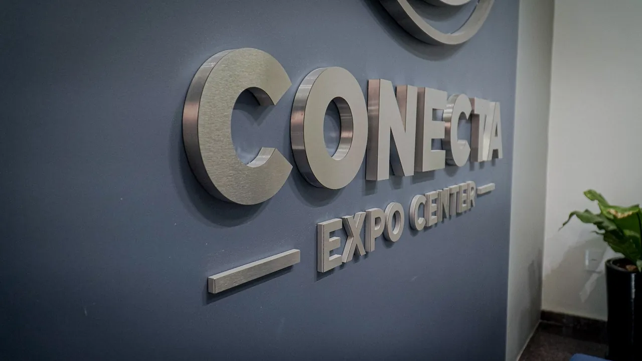 Letreiro 3D em aço escovado do Conecta Expo Center na parede azul da recepção